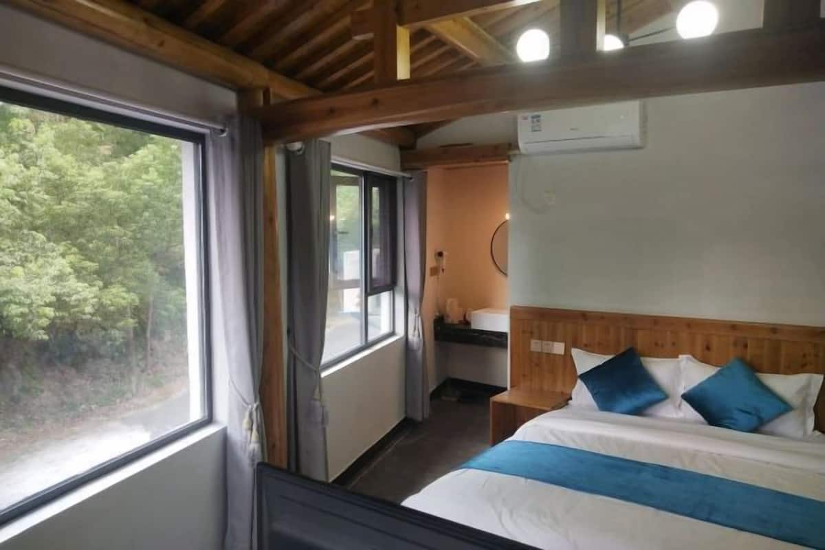 Una habitación con cama, ventana y baño.