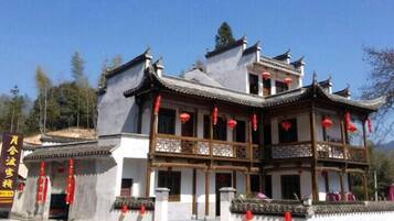A traditional building with multiple levels, balconies, and red lanterns.