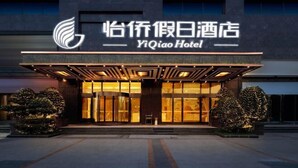 A hotel entrance with a modern facade, large glass doors, and a prominent logo. - Yi Qiao Hotel (Chengdu)