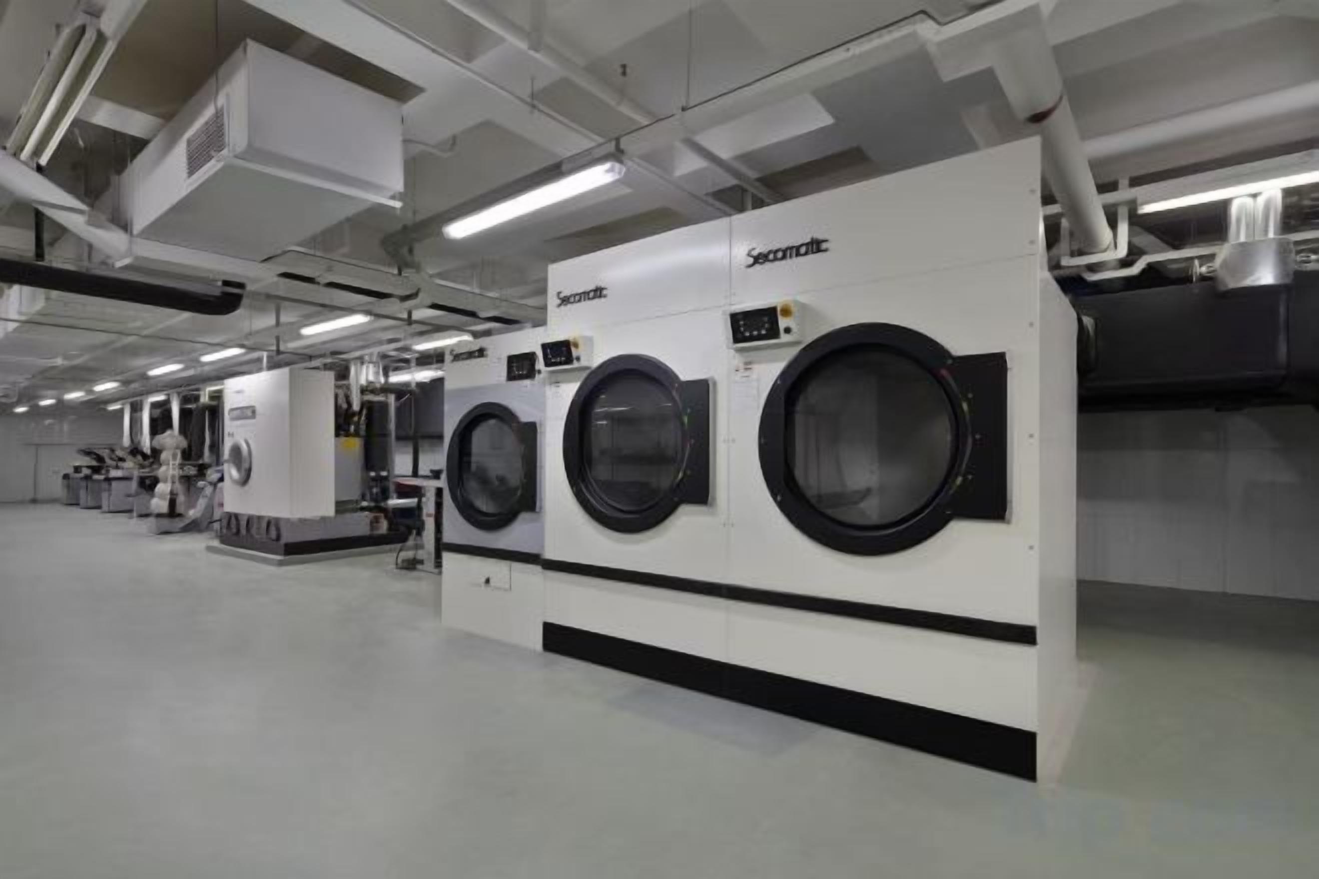 A large industrial-style laundry facility with multiple washing machines.