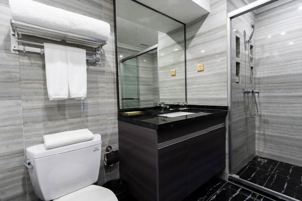 A modern bathroom with a toilet, sink, and shower.