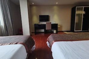 A hotel room with two beds, a desk with a TV, and a wardrobe. - Teng Chuan Hotel (Lichuan)