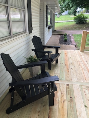 A wooden deck with two Adirondack chairs and a small table. - White Oak Cottage (Harrison)