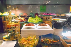 A buffet with various dishes and food items displayed in decorative containers. - Orange Hotel Select (Beijing Yizhuang Wanyuan Street) (Beijing)