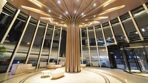 A modern lobby with a central column, seating areas, and large windows. - Orange Hotel Select (Beijing Yizhuang Wanyuan Street) (Beijing)