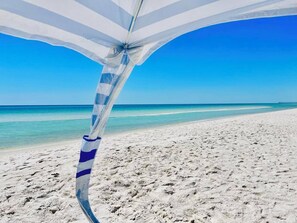 Ein Strand mit blauem Himmel und sandigem Ufer.