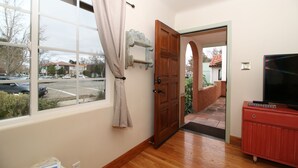 Ein Zimmer mit einem großen Fenster, einer Holztür und einem roten Schrank.