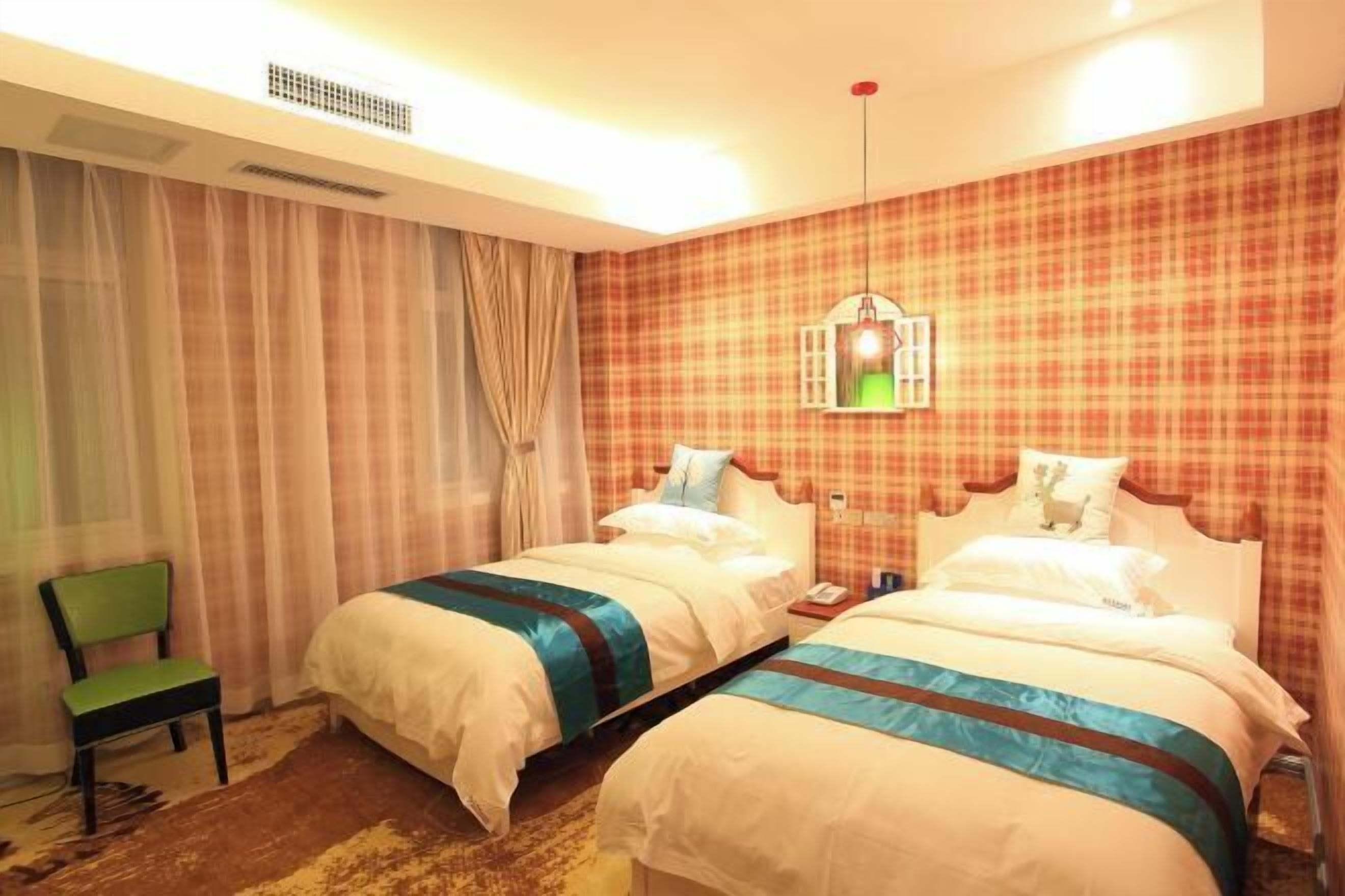 Une chambre d’hôtel avec deux lits, une chaise, une table de chevet, une lampe et une fenêtre avec des rideaux.