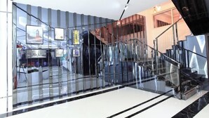 A modern interior with a glass wall, a staircase, and a seating area with white furniture.