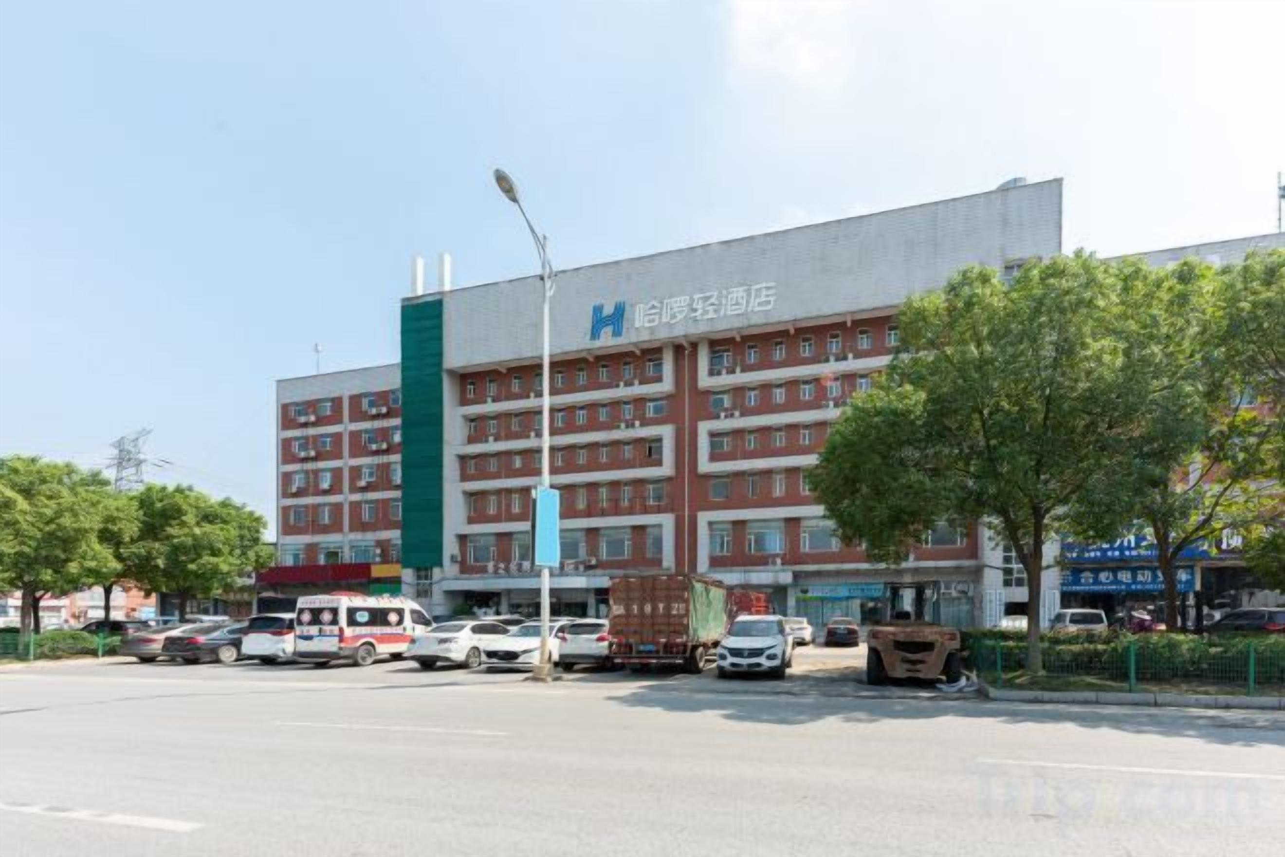 A multi-story hotel with a prominent HIA logo, a parking lot, and a street view.