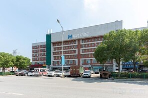 A multi-story hotel with a prominent HIA logo, a parking lot, and a street view. - Hello Light Hotel (Wuhan Hankou North Road Branch) (Wuhan)