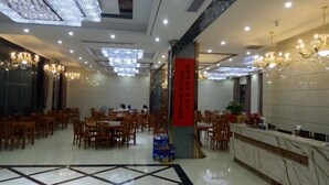 A spacious hotel lobby with multiple dining tables and chairs, a reception desk, and decorative chandeliers. - Yu Shan Hua Ting Holiday Hotel (Pingjiang)