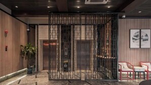 A modern lobby with a marble floor, a wooden wall, a metal partition, and red chairs. - Yiju Hotel (Shanghai Chuansha Branch) (Shanghai)
