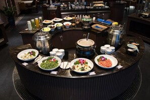 A buffet setup with various food items and condiments.