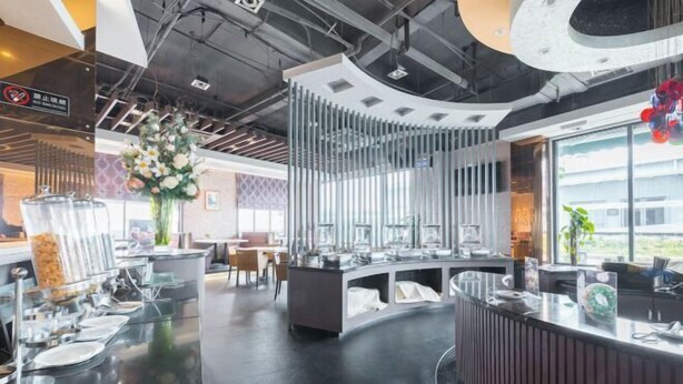 A modern restaurant with a curved counter, glassware, and a decorative flower arrangement. - Yiju Hotel (Shanghai Chuansha Branch) (Shanghai)