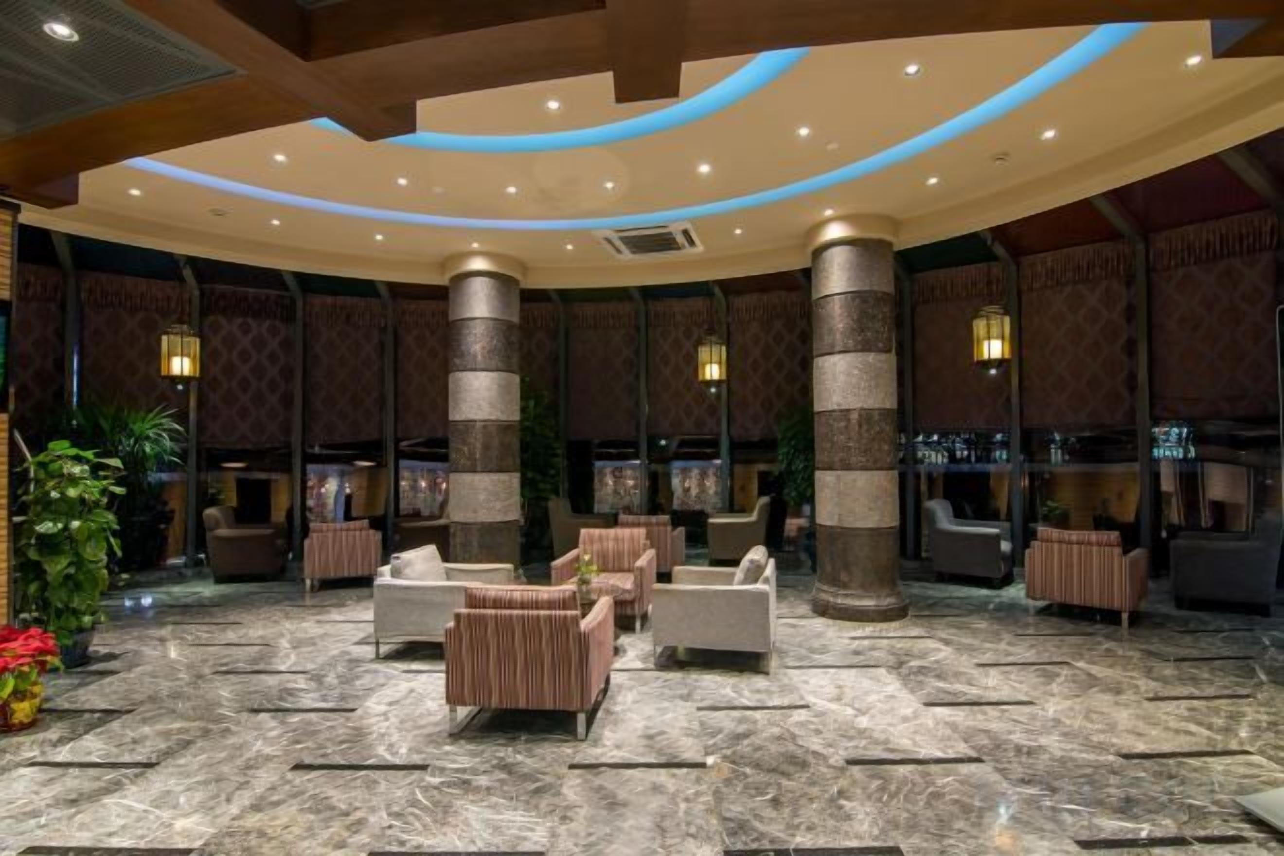 A lobby with a marble floor, seating areas, and a reception desk.