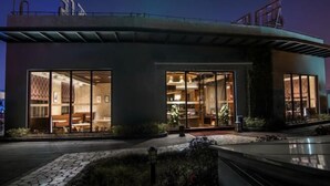 A modern building with large glass windows, a curved roof, and a well-lit interior. - Yiju Hotel (Shanghai Chuansha Branch) (Shanghai)