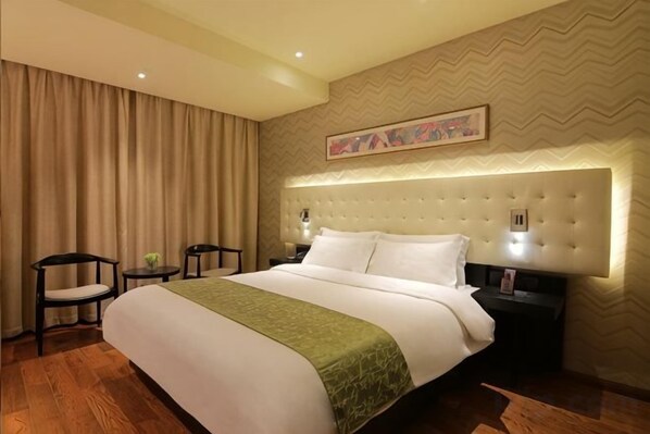 A hotel room with a large bed, two bedside tables, a headboard with built-in lighting, and a decorative wall piece. - Yiju Hotel (Shanghai Chuansha Branch) (Shanghai)