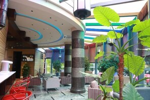 A spacious indoor area with a high ceiling, a central column, and seating arrangements. - Yiju Hotel (Shanghai Chuansha Branch) (Shanghai)