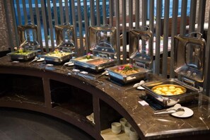 A buffet setup with various food items and serving utensils. - Yiju Hotel (Shanghai Chuansha Branch) (Shanghai)