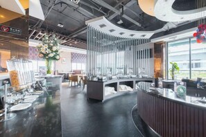 A modern hotel lobby with a curved reception desk, a large flower arrangement, and a view of the outdoors. - Yiju Hotel (Shanghai Chuansha Branch) (Shanghai)