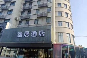 A hotel with a sign that reads '逸居酒店' on the facade. - Yiju Hotel (Shanghai Chuansha Branch) (Shanghai)