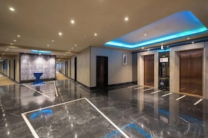 A hotel lobby with a marble floor, a reception desk, and a blue decorative piece. - Yiju Hotel (Shanghai Chuansha Branch) (Shanghai)