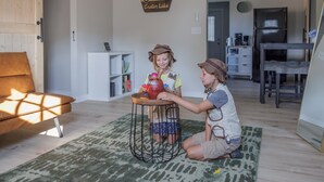 A living room with a sofa, a coffee table, and a rug. There is a sign on the wall that says "Welcome to our house." - Crater Lake House l Close to Hwy 97 l  OIT l Skylake l Family l Pet Friendly (Klamath Falls)