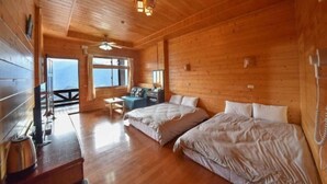 A wooden cabin with two beds, a desk, and a window with a view. - Beverly Hills (Nantou)