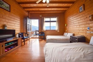 A wooden cabin room with a TV, two beds, a desk, and a chair. - Beverly Hills (Nantou)