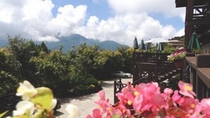 A restaurant with outdoor seating overlooking a mountain. - Beverly Hills (Nantou)