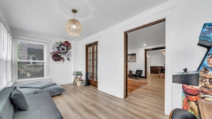 A modern living room with a grey sofa, wooden flooring, and a large mirror.