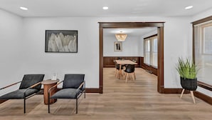 A modern hotel lobby with a reception desk, seating area, and a dining space.