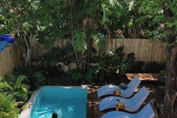 A swimming pool with lounge chairs and a wooden deck. - Sense of Haiya (Chiang Mai)