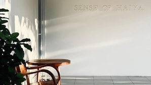 A room with a wooden chair and a wall with the text "SENSE OF HAJYA". - Sense of Haiya (Chiang Mai)