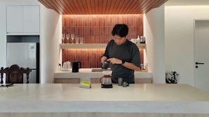 A modern kitchen with a wooden ceiling, a coffee maker, and a countertop. - Sense of Haiya (Chiang Mai)