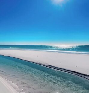Ein Strand mit klarem Wasser und einem weißen Sandufer.