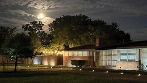 A modern house with a brick facade, large windows, and a well-maintained lawn. - NEAR CAMPUS! Choice KING or QUEEN BEDS w fresh interior paint & great parking! (College Station)