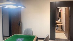 A room with a green pool table, a ceiling light fixture, and a doorway leading to a bathroom. - Shell Hotel (Zhuhai Doumen Daxin Xinduhui) (Zhuhai)