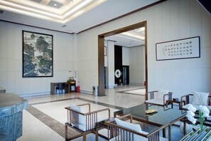 Welcome to our lobby, featuring a reception desk, comfortable seating area, and a striking piece of artwork.