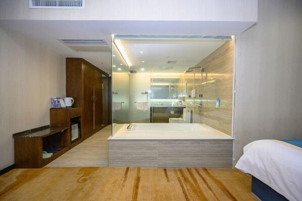 A modern hotel room with a large bathtub, a wooden cabinet, and a glass-enclosed shower area. - Po Cheng Hotel (Weiyuan)