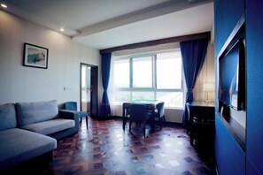 Relax in a spacious room with a sofa, dining table, and large window.