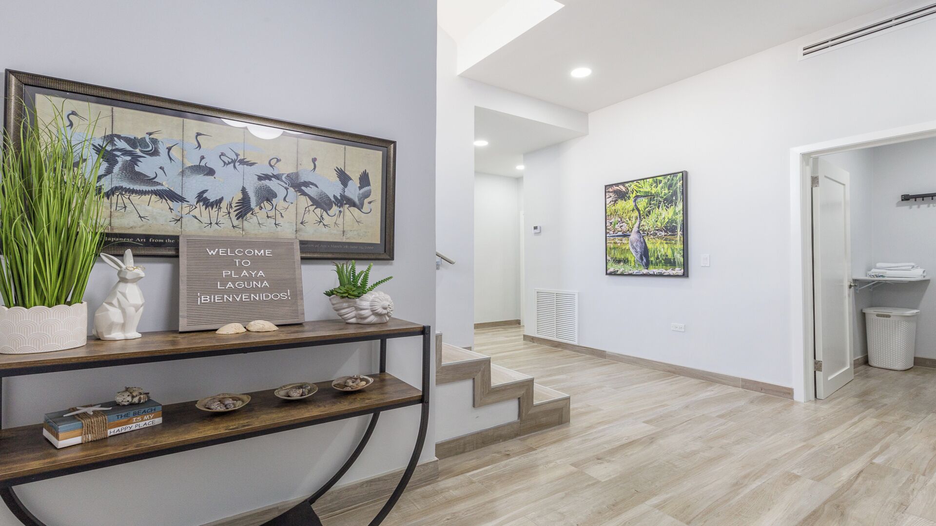 Un intérieur moderne comprenant un comptoir d’accueil, des œuvres d’art et un escalier menant à un autre espace.