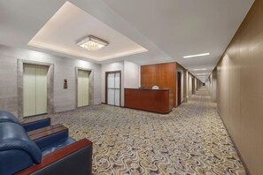 A hotel lobby with a reception desk, two elevators, and a patterned carpet. - Yinwan Hotel( South China country garden store) (Guangzhou)
