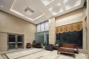 A spacious lobby with a large seating area, a reception desk, and a glass partition. - Yinwan Hotel( South China country garden store) (Guangzhou)