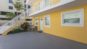 A yellow building with a white balcony, a staircase, and a small outdoor seating area. - ULTRA exciting Apartment at Boardwalk  (Hollywood)