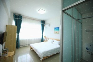 A bedroom with a bed, a TV, a window with curtains, and a shower area. - Gangfeng Express Hotel (Beihai)