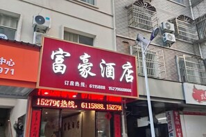 A hotel sign with contact numbers and a red awning. - Fuhao Hotel Suichuan (Suichuan)