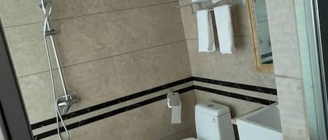 A bathroom with a shower, toilet, and sink.