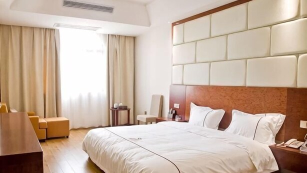 A hotel room with a large bed, a desk, a chair, and a sofa. - Fuhao Hotel Suichuan (Suichuan)